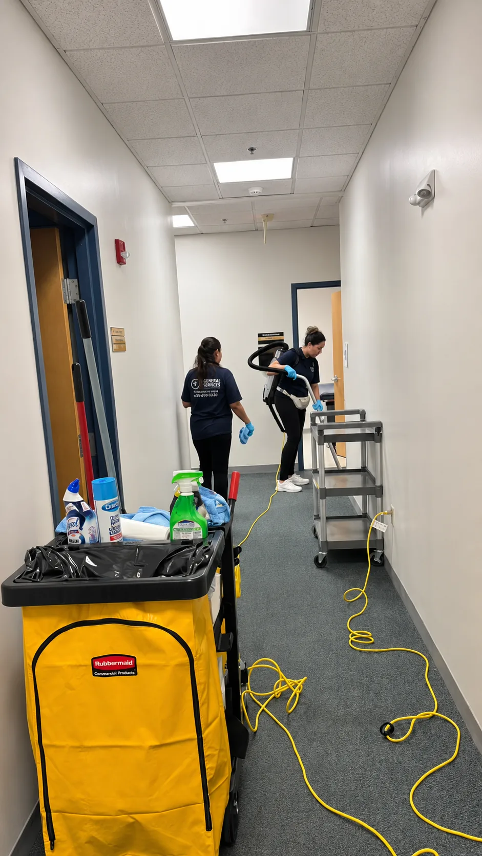 7 General Services team performing commercial janitorial cleaning in an office corridor in Greater Boston, MA